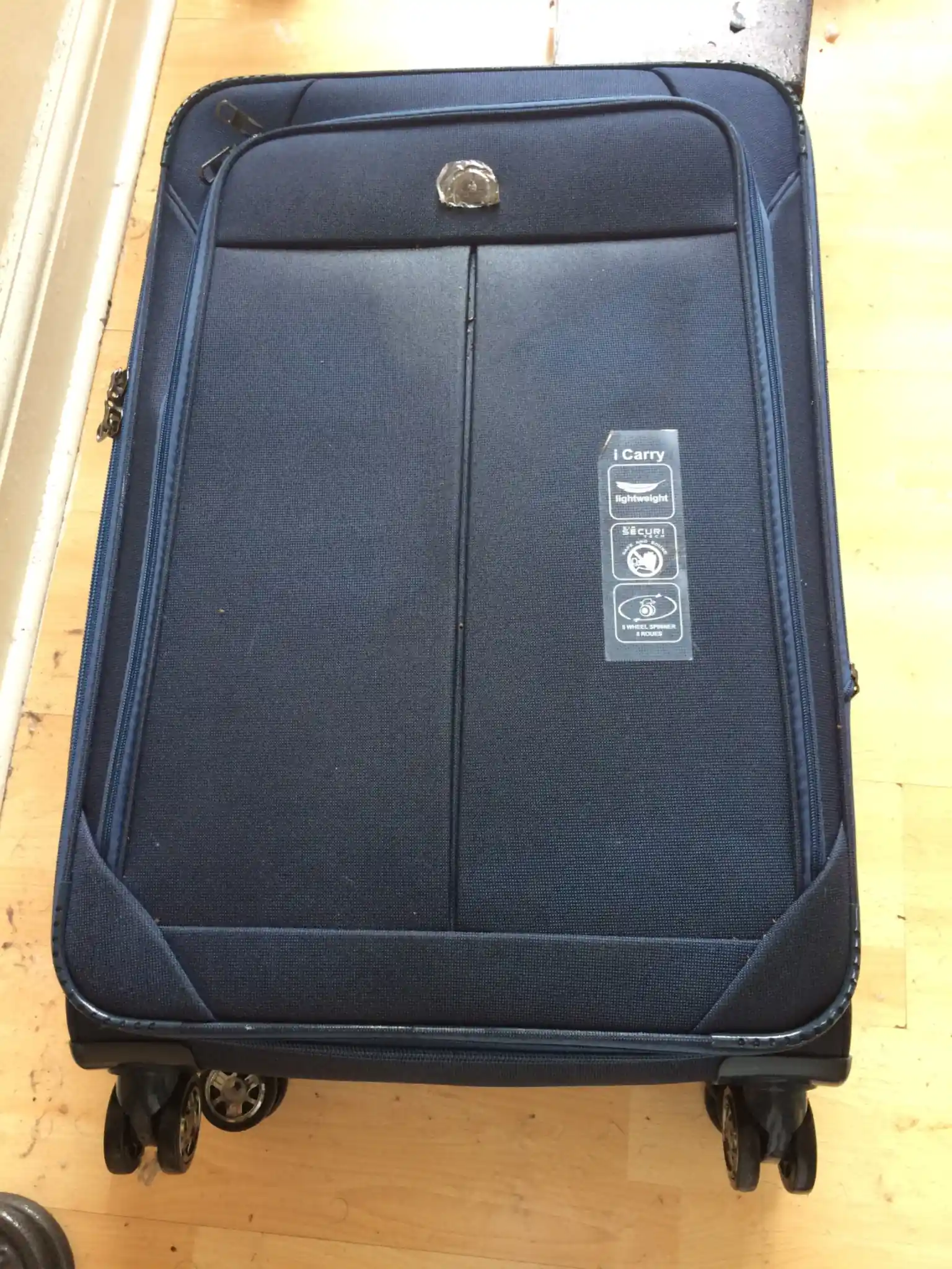 Store luggage on hard surfaces away from beds when travelling. Suitcase on a hard floor — keep luggage away from beds to prevent bed bug hitchhikers